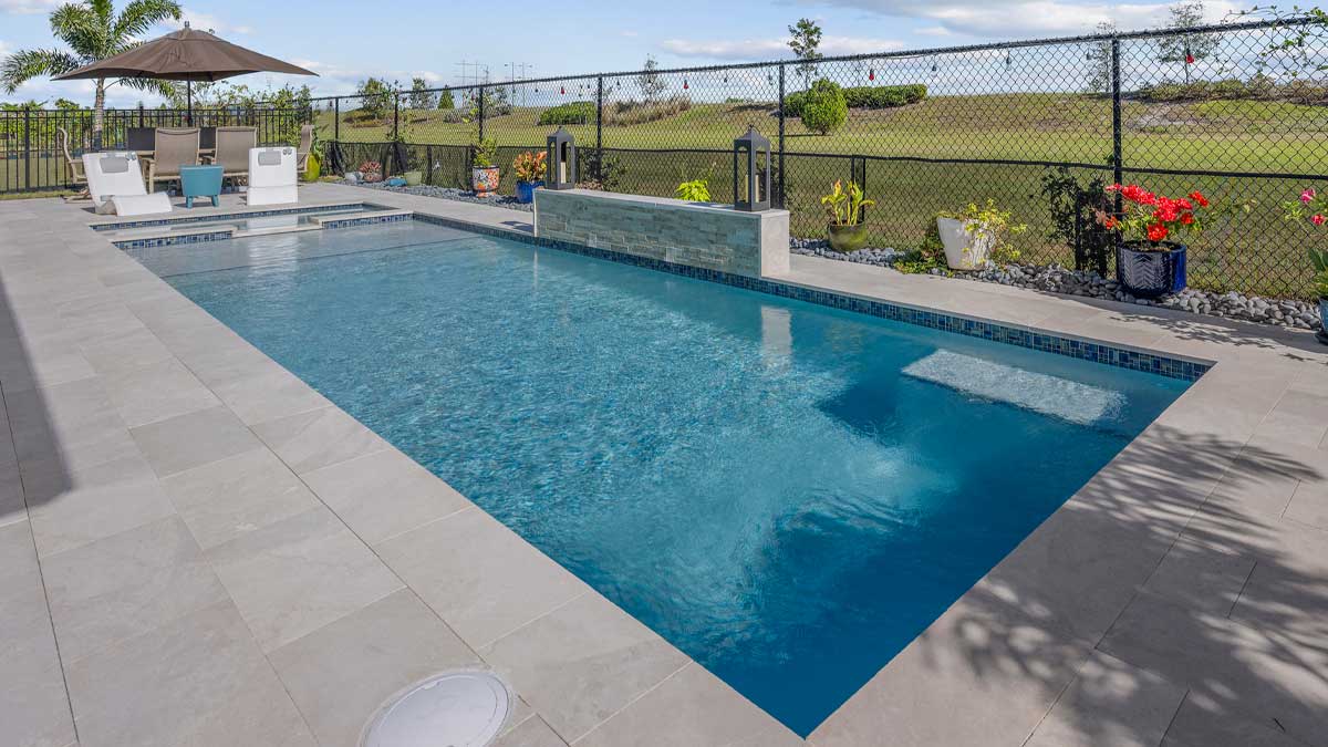 a Reliable pool care technician taking chemical readings of pool water on the edge of a pool overlooking the Texas hill country