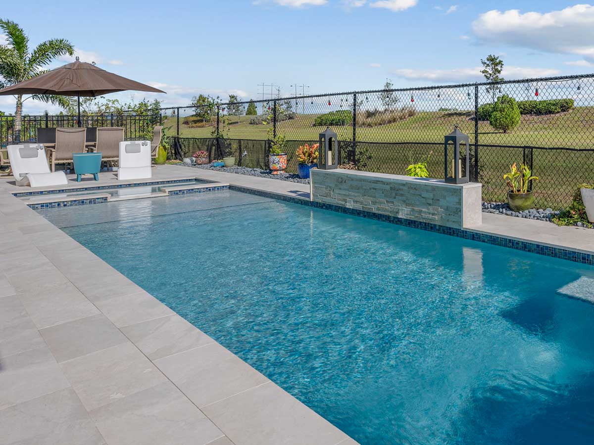 a Reliable pool care specialist taking chemical readings of pool water on the edge of a pool overlooking the Texas hill country